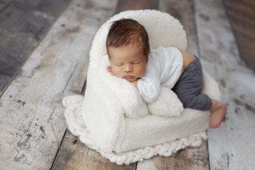 Noworodek leżący na plecach – sesja noworodkowa studio Wyszków