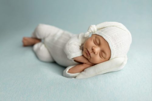 Noworodek spokojnie śpiący na boku – fotografia noworodkowa Wyszków