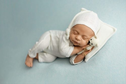 Noworodek spokojnie śpiący na boku – fotografia noworodkowa Wyszków