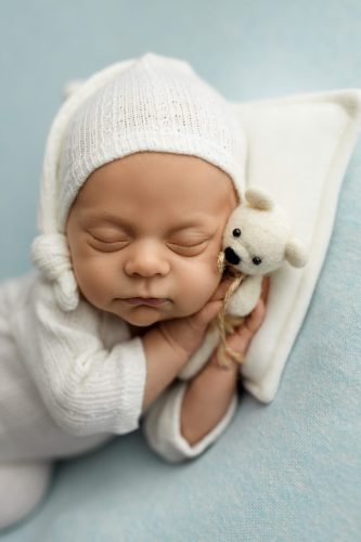 Noworodek spokojnie śpiący na boku – fotografia noworodkowa Wyszków