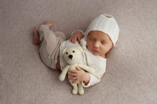 Noworodek leżący na plecach – sesja noworodkowa studio Wyszków