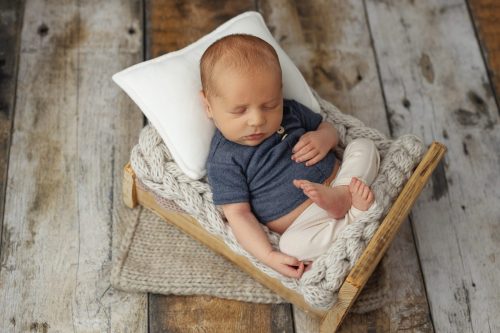 Noworodek leżący na plecach – sesja noworodkowa studio Wyszków