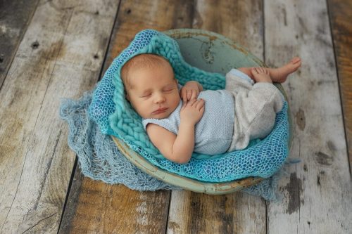 Noworodek leżący na plecach – sesja noworodkowa studio Wyszków