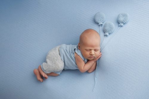 Noworodek leżący na boku – sesja noworodkowa studio Wyszków