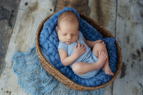 Noworodek leżący na plecach – sesja noworodkowa studio Wyszków