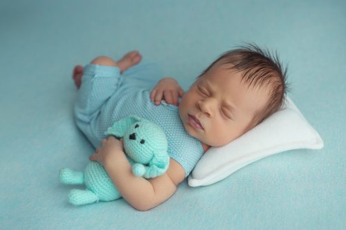 Noworodek leżący na plecach – sesja noworodkowa studio Wyszków