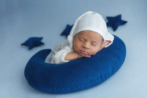 Noworodek leżący na plecach – sesja noworodkowa studio Wyszków