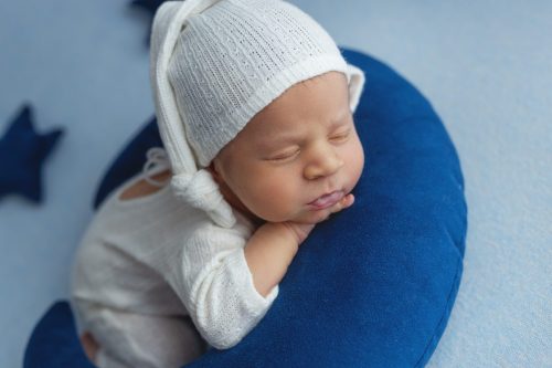 Noworodek leżący na plecach – sesja noworodkowa studio Wyszków