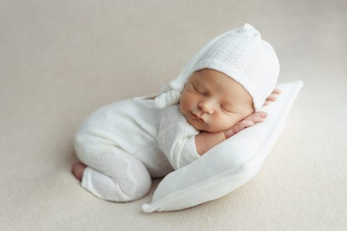 Noworodek leżący na plecach – sesja noworodkowa studio Wyszków