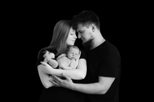 Rodzice z noworodkiem w ramionach – sesja noworodkowa Wyszków