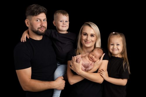 Rodzice z noworodkiem w ramionach – sesja noworodkowa Wyszków