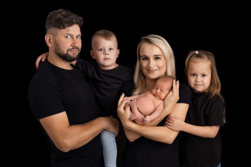 Rodzice z noworodkiem w ramionach – sesja noworodkowa Wyszków