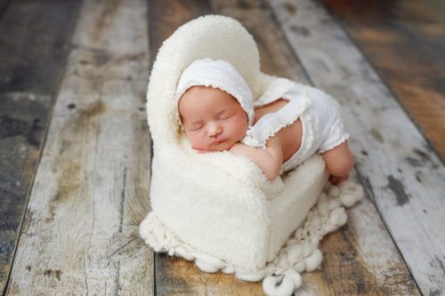 Noworodek leżący na brzuszku – sesja noworodkowa studio Wyszków