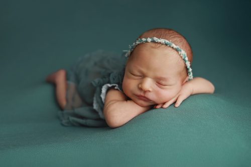 Noworodek leżący na brzuszku – sesja noworodkowa studio Wyszków