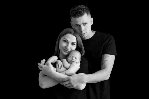 Rodzice przytulający noworodka – sesja noworodkowa w studio Wyszków