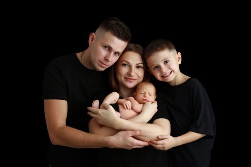 Rodzice przytulający noworodka – sesja noworodkowa w studio Wyszków