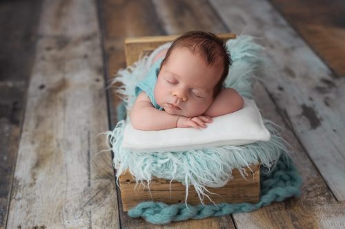 Noworodek leżący na brzuszku – sesja noworodkowa studio Wyszków