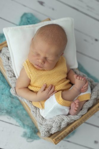 Noworodek leżący na plecach – sesja noworodkowa studio Wyszków