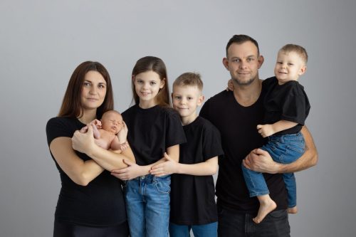 Rodzice z noworodkiem w ramionach – sesja noworodkowa Wyszków