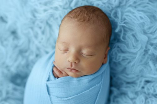 Noworodek na niebieskim tle – fotografia noworodkowa Wyszków