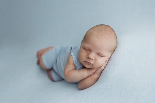 Noworodek na niebieskim tle – fotografia noworodkowa Wyszków