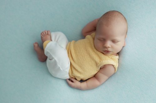 Spokojny noworodek podczas snu – sesja noworodkowa Wyszków