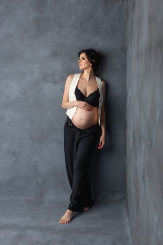 Kobieta w ciąży stojąca w studio – fotografia ciążowa Wyszków