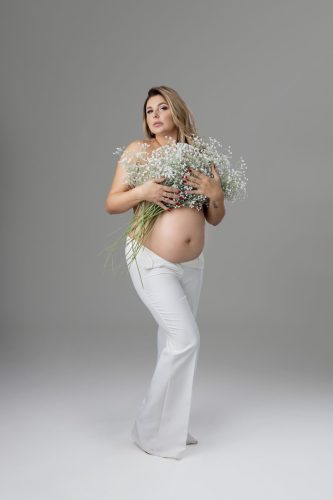 Kobieta w ciąży z kwiatami – sesja ciążowa Wyszków